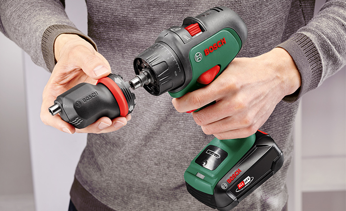 Jemand hält ein Bosch Akkuschrauber in der Hand un wechselt den Aufsatz