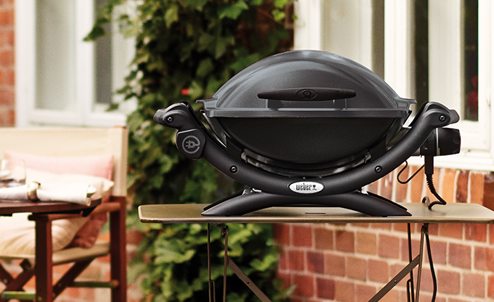 Ein Elektrogrill auf einem Tisch in einem Garten