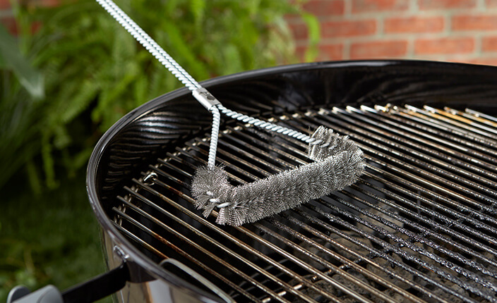 Eine Grillbürste auf einem Grillrost