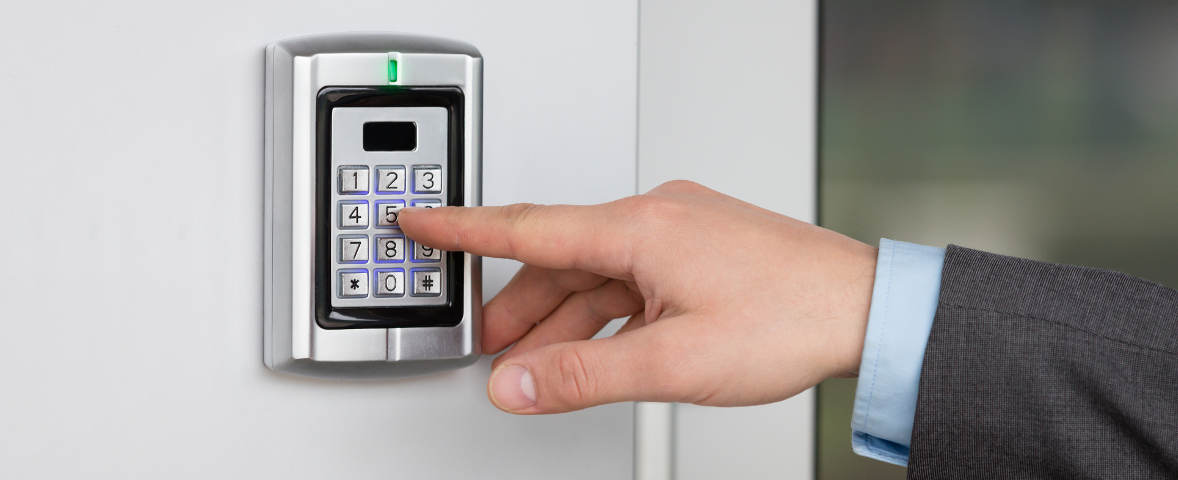 Eine Person tippt einen Zahlencode auf einem elektronischen Türschloss ein.