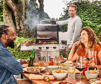 Vier Leute habenspaß bei einem Grillfest mit einem Grill im Hintergrund von Char-Broil