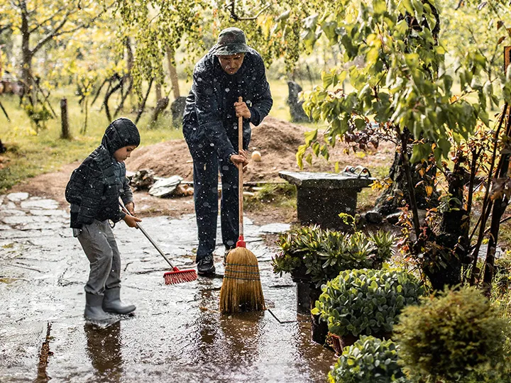 Vater und Sohn räumen nach Hochwasser auf