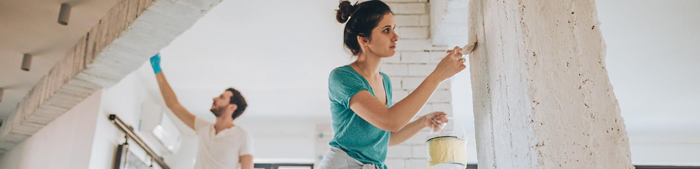 Zwei Personen streichen Wände in der Farbe weiß