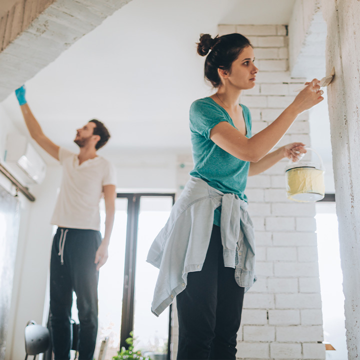 Zwei Personen streichen wände in der Farbe weiß