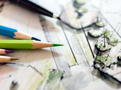 Buntstifte auf einem Gartenentwurf mit Skizzen und Zeichnungen.