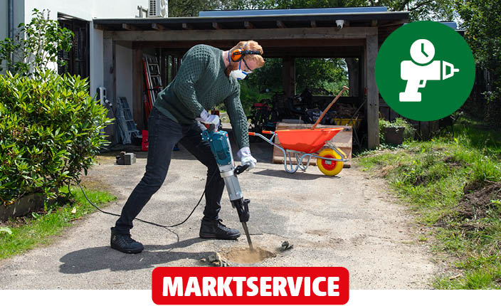 Ein Mann macht seine Auffahrt mit eine Schlagbohrmaschine frei