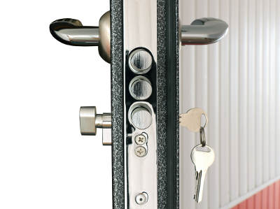 Seitenansicht einer geöffneten Sicherheitstür mit eingebautem Schließzylinder, der Schlüssel steckt im Schloss, mehrere Bolzen sind im Türrahmen sichtbar